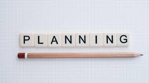 Scrabble tiles spelling the word planning with a pencil underlining the word